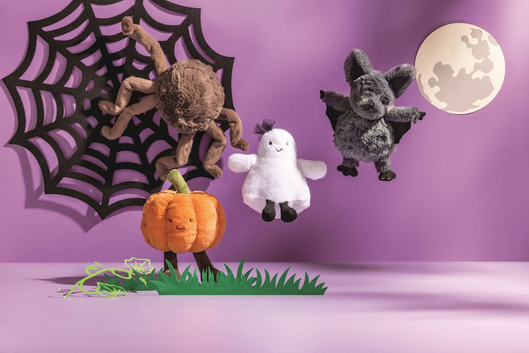Halloween-themed plush toys including a spider, ghost, and bat on a purple background with a spider web and moon.