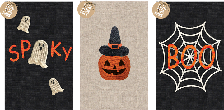 Three Halloween-themed tea towels with ghost, pumpkin, and spider web designs.