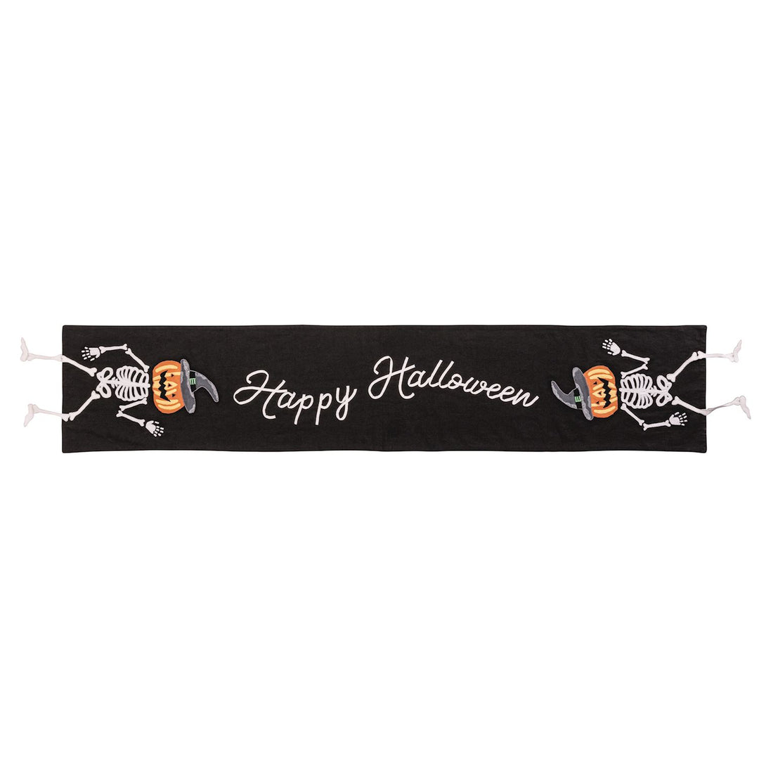 A black table runner with 'Happy Halloween' text and skull motifs.