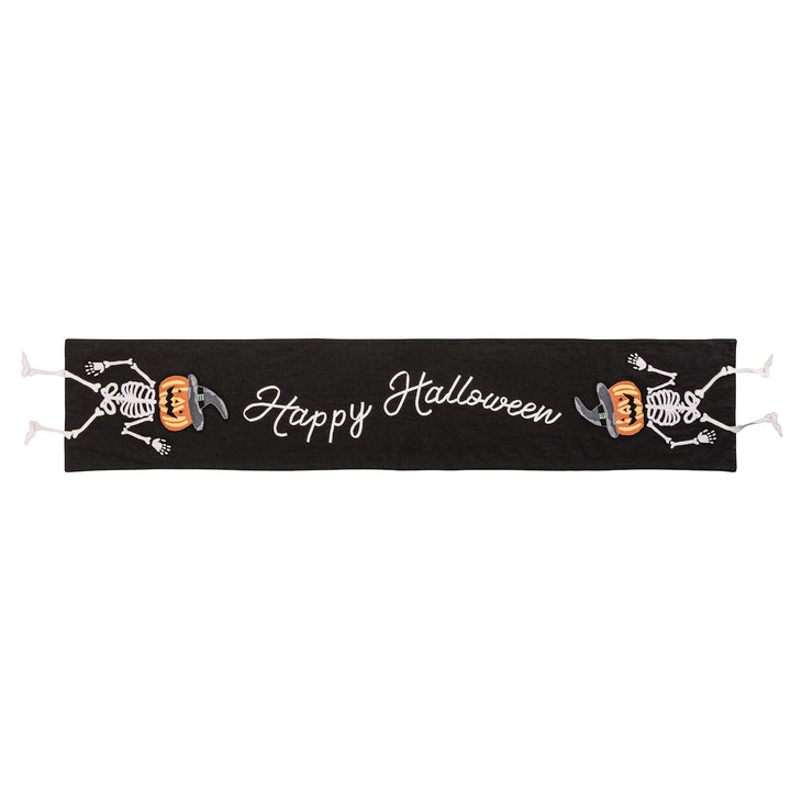 A black table runner with 'Happy Halloween' text and skull motifs.
