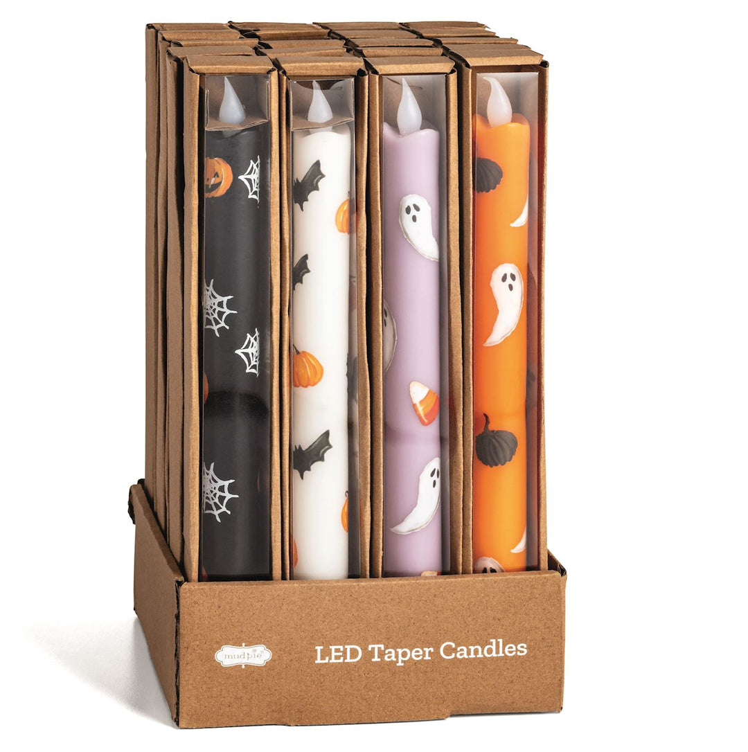 LED taper candles for Halloween, with various designs including ghosts, pumpkins, and bats, displayed in a cardboard box.