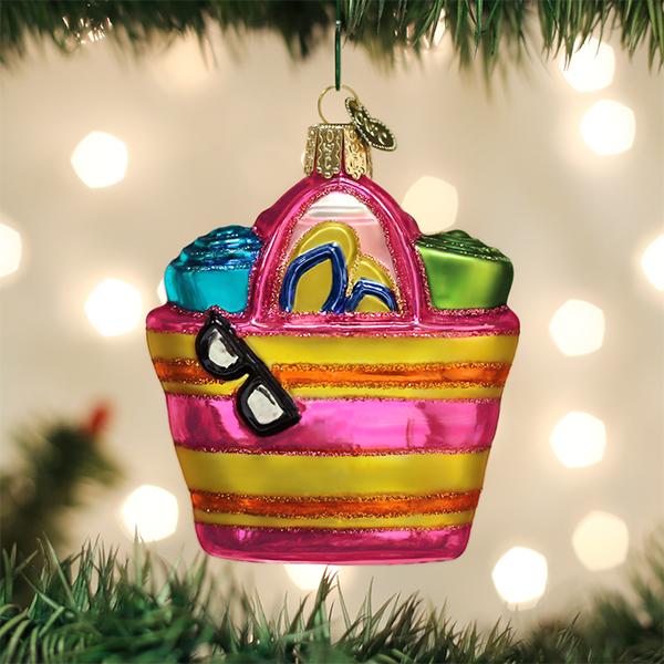 Colorful beach bag ornament with sunglasses on a Christmas tree.