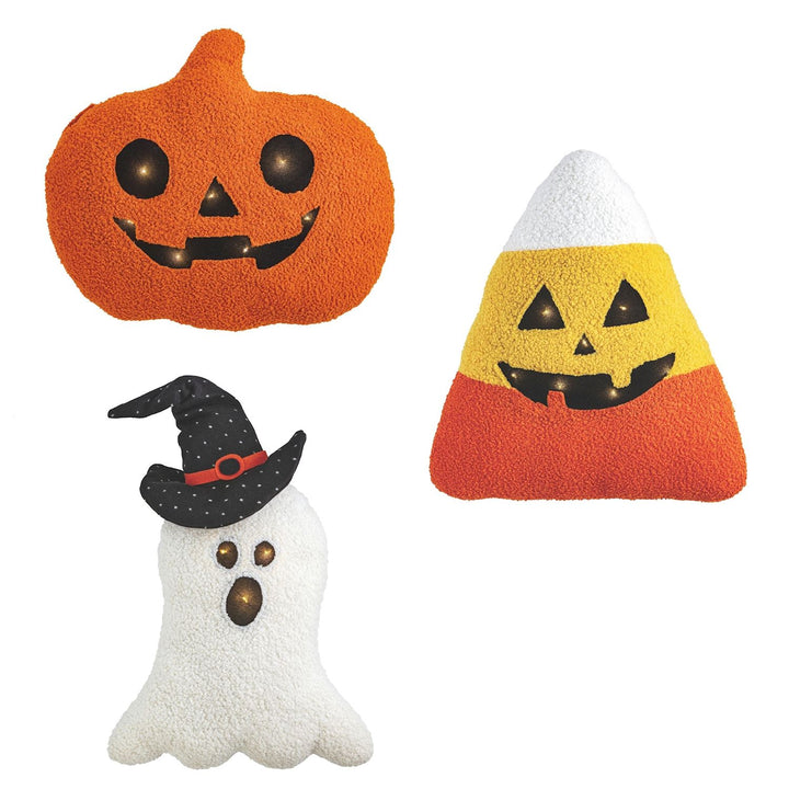 Three Halloween-themed pillows: a pumpkin, a ghost, and a candy corn on a white background.