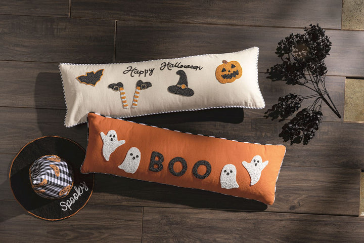 Two Halloween-themed decorative pillows on a wooden surface with decorative elements.