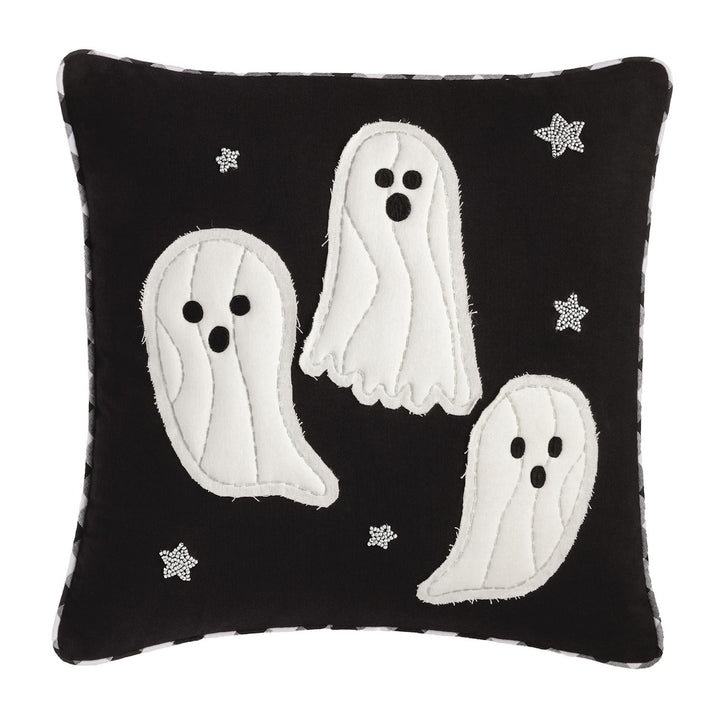 Black pillow with white ghost appliqués and star patterns on a white background