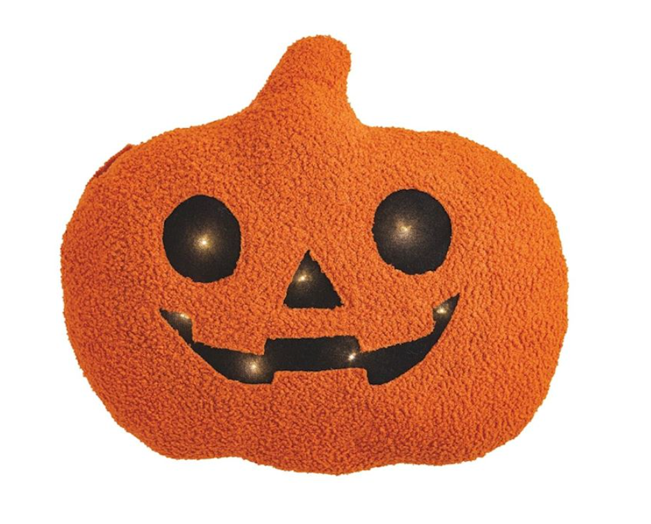 Pumpkin-shaped pillow with jack-o'-lantern face on a white background