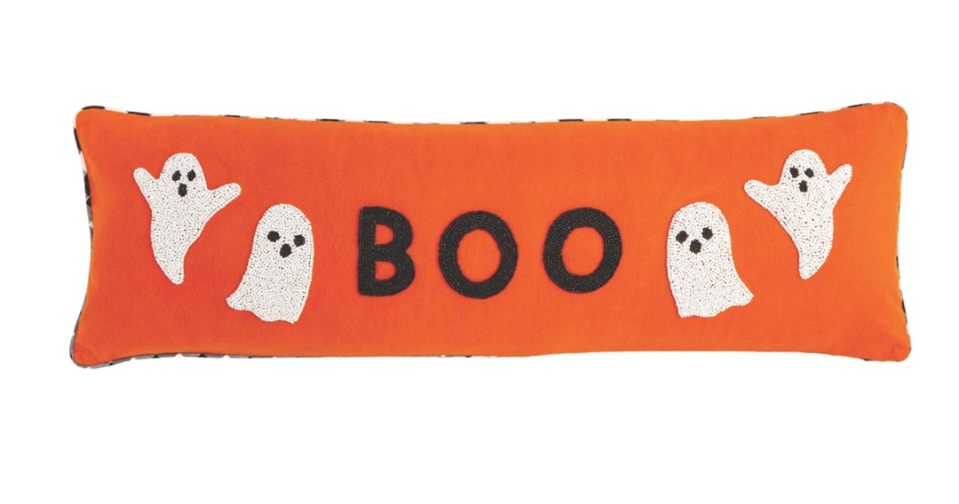 Halloween-themed pillow with 'BOO' and ghost designs on an orange background