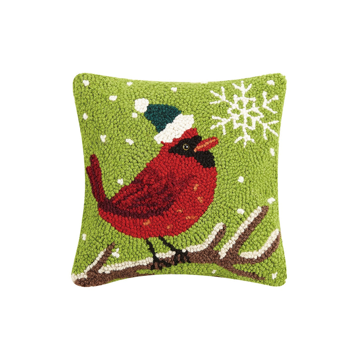 Decorative pillow with a red bird wearing a blue hat on a green background